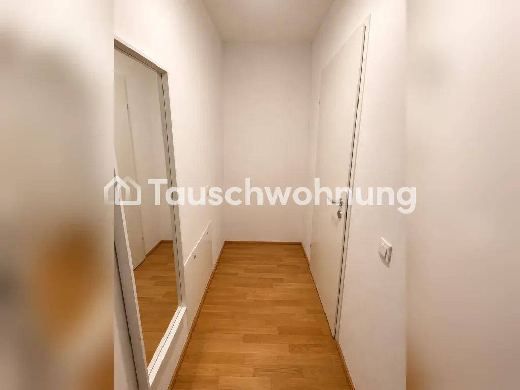 Schmaler Flur mit großem Spiegel und hellem Holzboden, der den Raum optisch erweitert.
