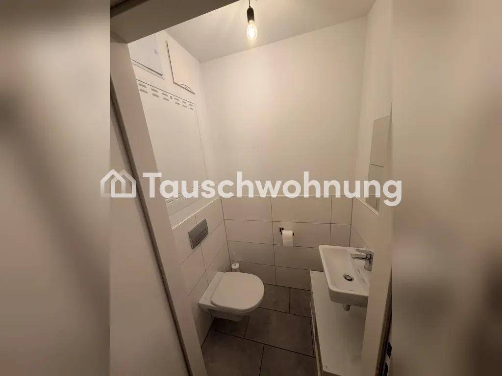 Kleines Gäste-WC mit Wand-WC, Waschbecken und Fliesenboden, funktional und sauber.