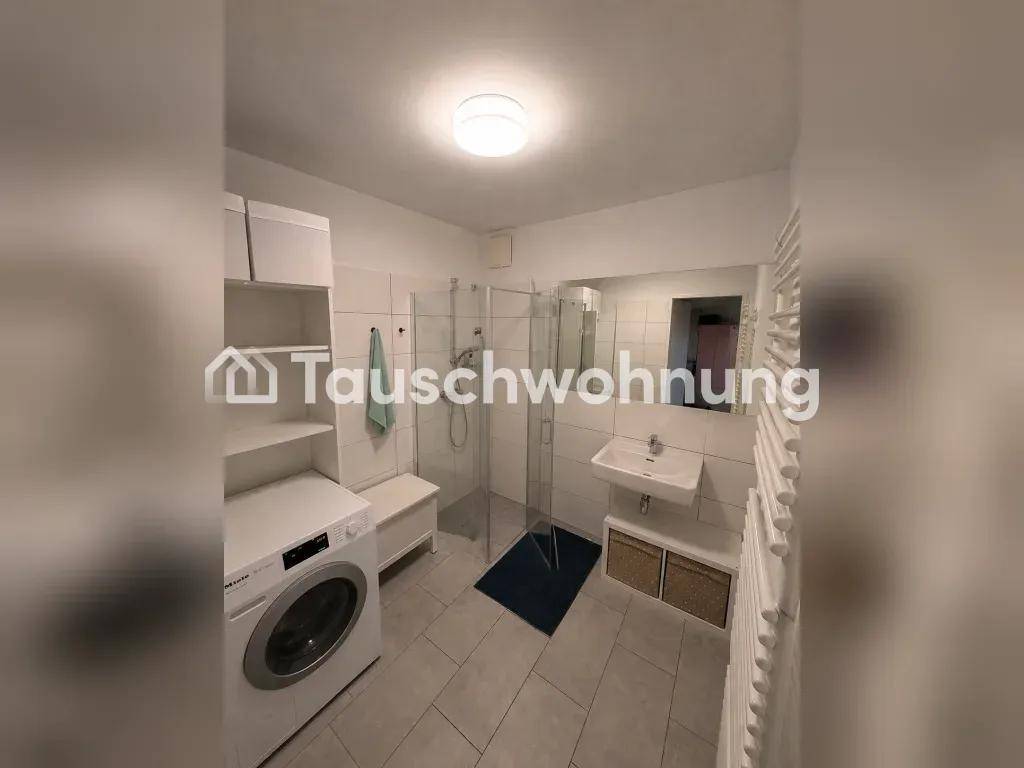 Modernes Badezimmer mit Dusche, Waschbecken, Waschmaschine und Handtuchheizkörper, hell und funktional.