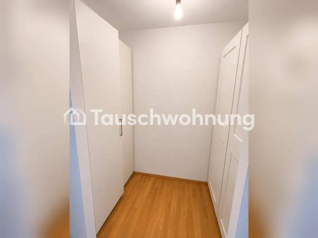 Praktischer begehbarer Kleiderschrank mit eingebauten weißen Schränken und Holzboden für viel Stauraum.