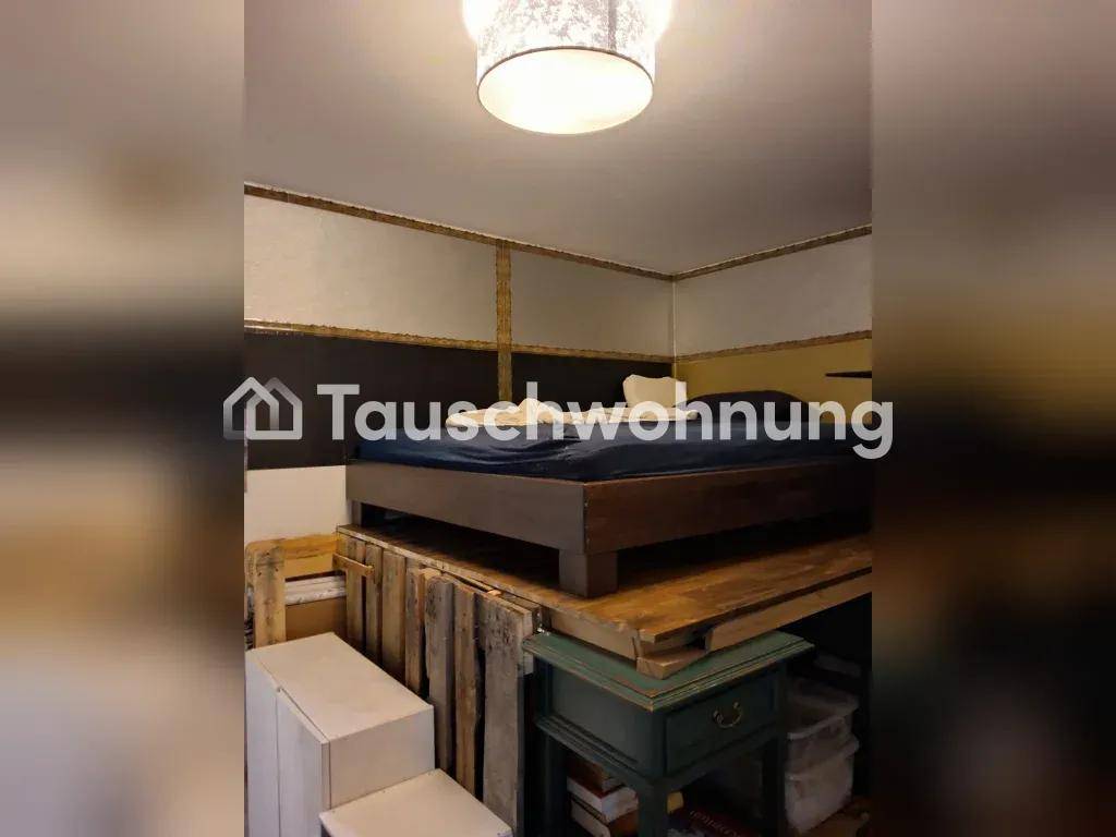 Schlafzimmer mit einem Bett auf einer erhöhten Plattform aus Paletten, darunter Stauraum.