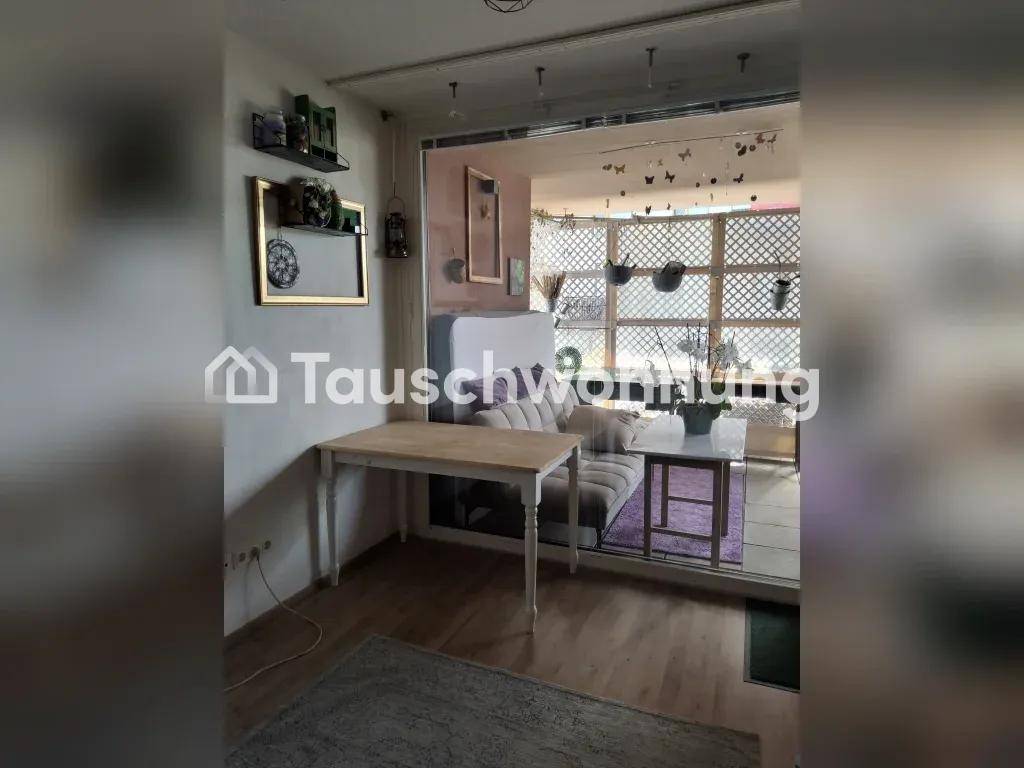 Wohnbereich mit kleinem Tisch und Sofa, angrenzend an einen hellen Wintergarten mit Gitterwänden.