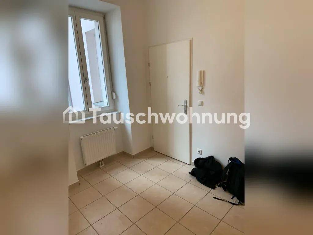 Eingangsbereich mit Fliesenboden, Fenster und Gegensprechanlage, bietet Zugang zur Wohnung.