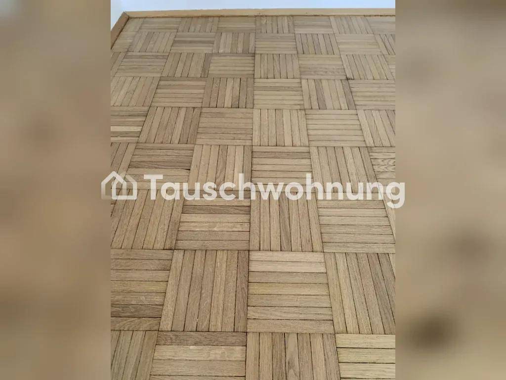 Detailaufnahme des klassischen Fischgrätparkettbodens, der den Raum prägt.