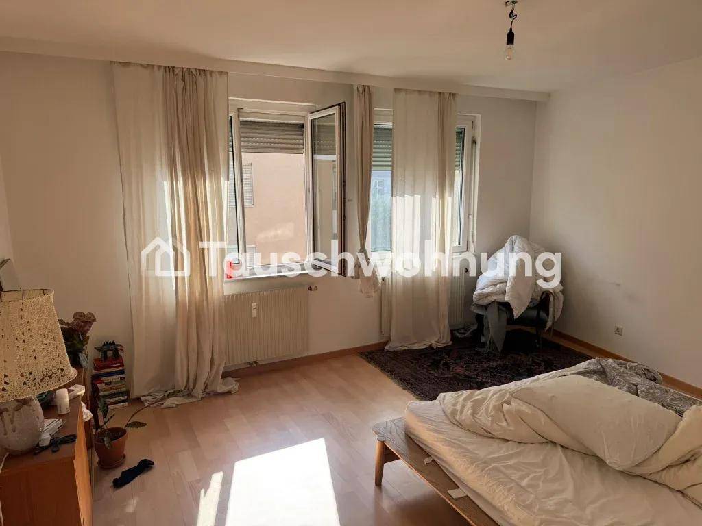 Helles Schlafzimmer mit einem Bett, großen Fenstern und einem Heizkörper.