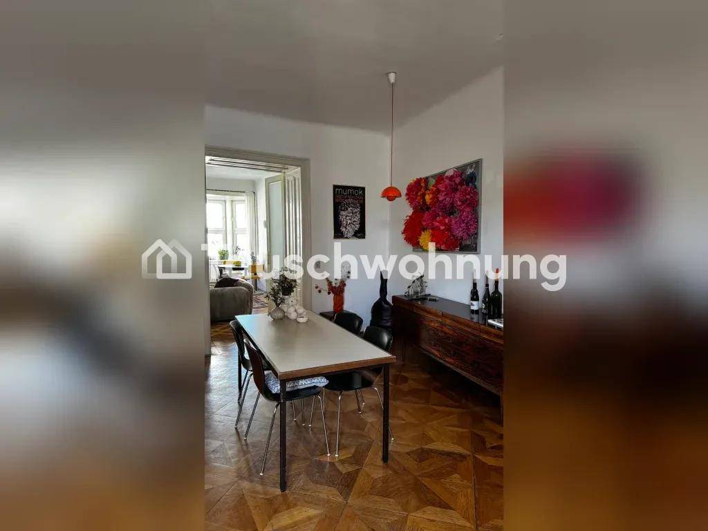Esszimmer mit großem Esstisch, Sideboard und farbenfroher Wanddekoration.