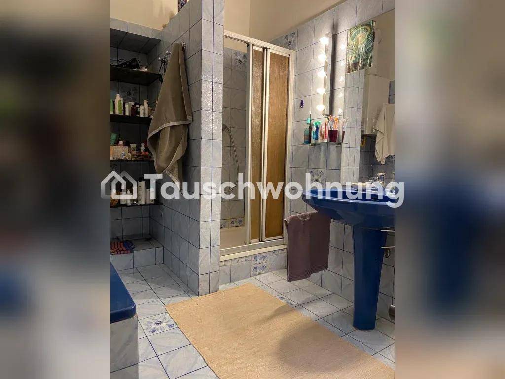 Badezimmer mit blauen Fliesen, Duschkabine und einem einzelnen Waschbecken.