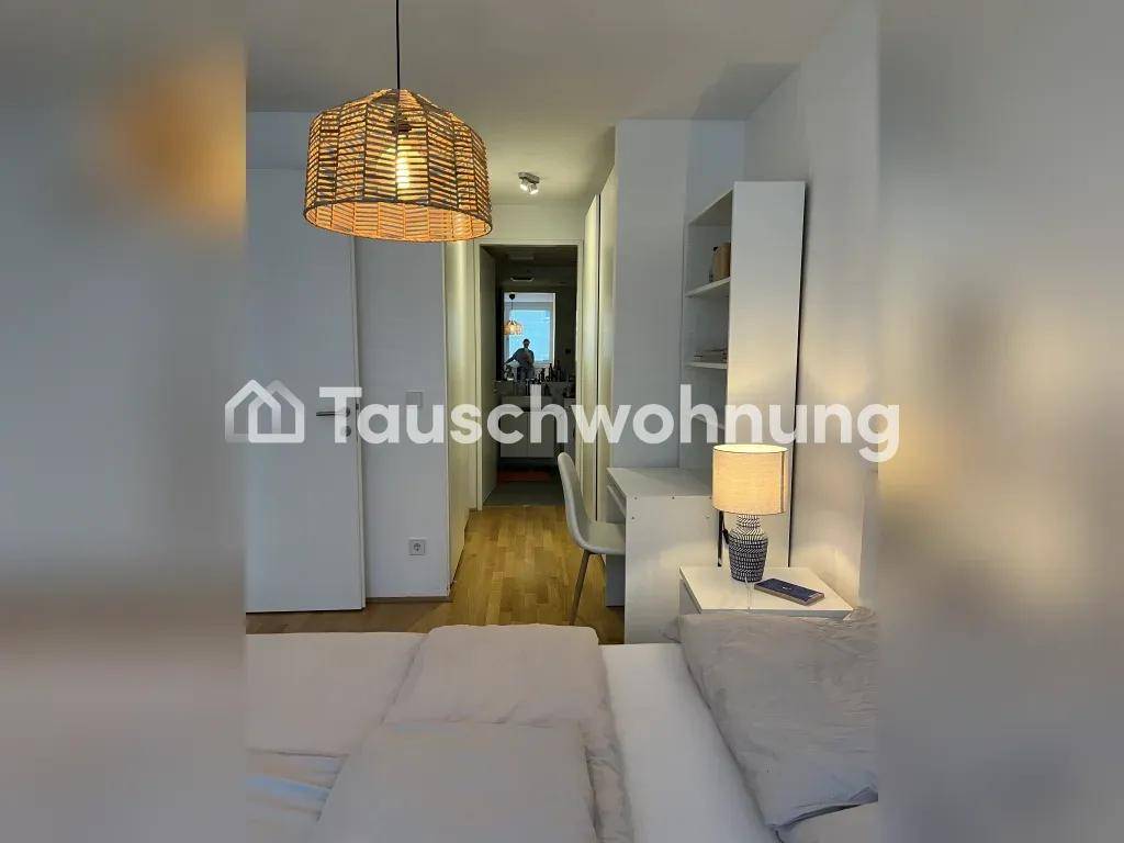 Schlafzimmer mit Schreibtisch, Regal und Blick in den angrenzenden Flur.