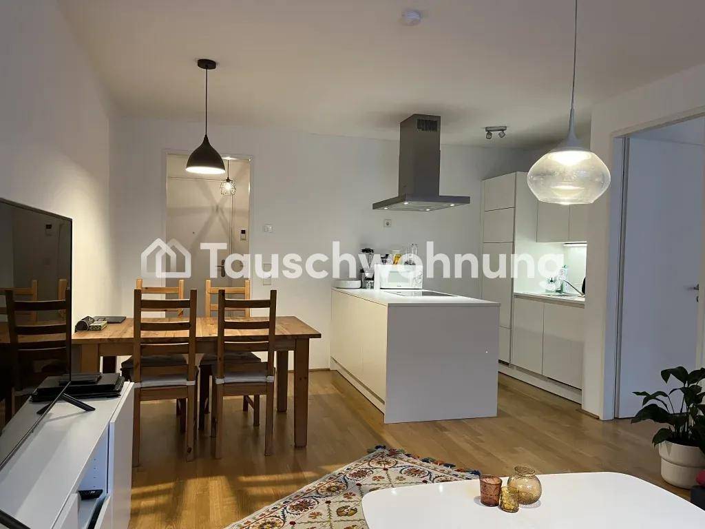 Offener Wohn- und Essbereich mit moderner Küche, Holztisch und großen Fenstern.