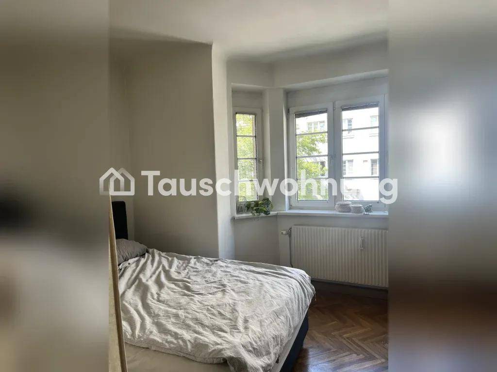 Helles Schlafzimmer mit Bett, Fischgrätparkett und einem charmanten Erkerfenster.