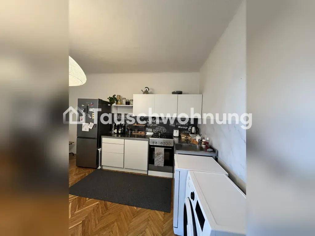 Funktionale Küche mit weißen Schränken, Kühlschrank und Waschmaschine.