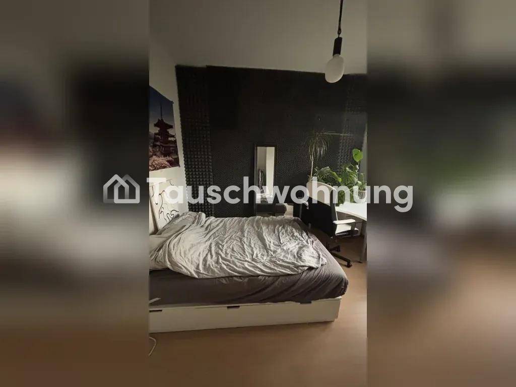 Schlafzimmer mit Bett, Schreibtisch und schallabsorbierenden Paneelen an der Wand.