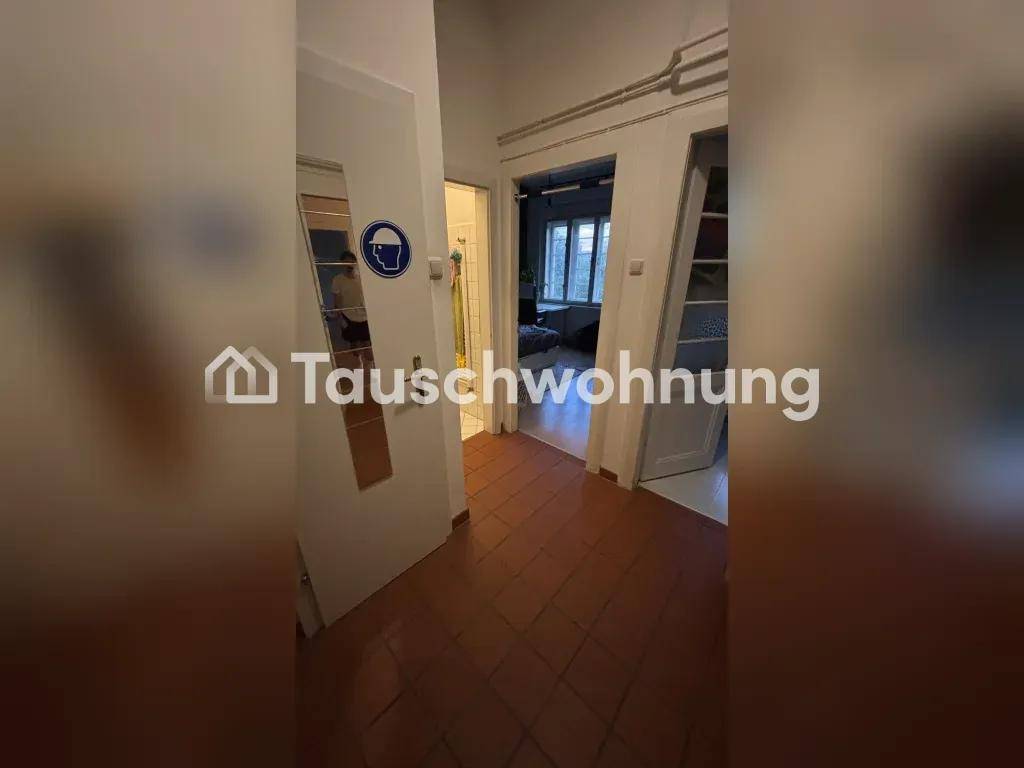 Langer Flur mit braunen Fliesen, der den Zugang zu verschiedenen Zimmern ermöglicht.