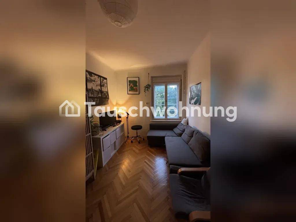 Wohnzimmer mit Sofa, TV-Möbeln, Fischgrätparkett und einem Fenster, das Licht hereinlässt.