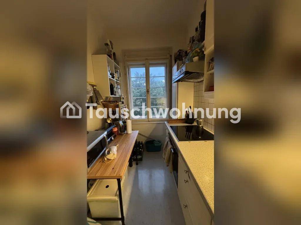 Küche mit Fenster, Einbaugeräten und einer Arbeitsplatte aus hellem Holz.