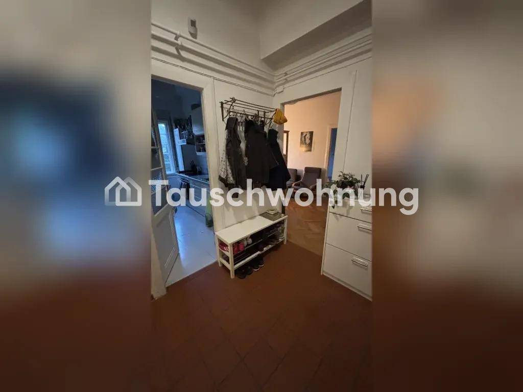 Eingangsbereich mit Fliesenboden, Garderobe und Schuhregal, der zu weiteren Räumen führt.