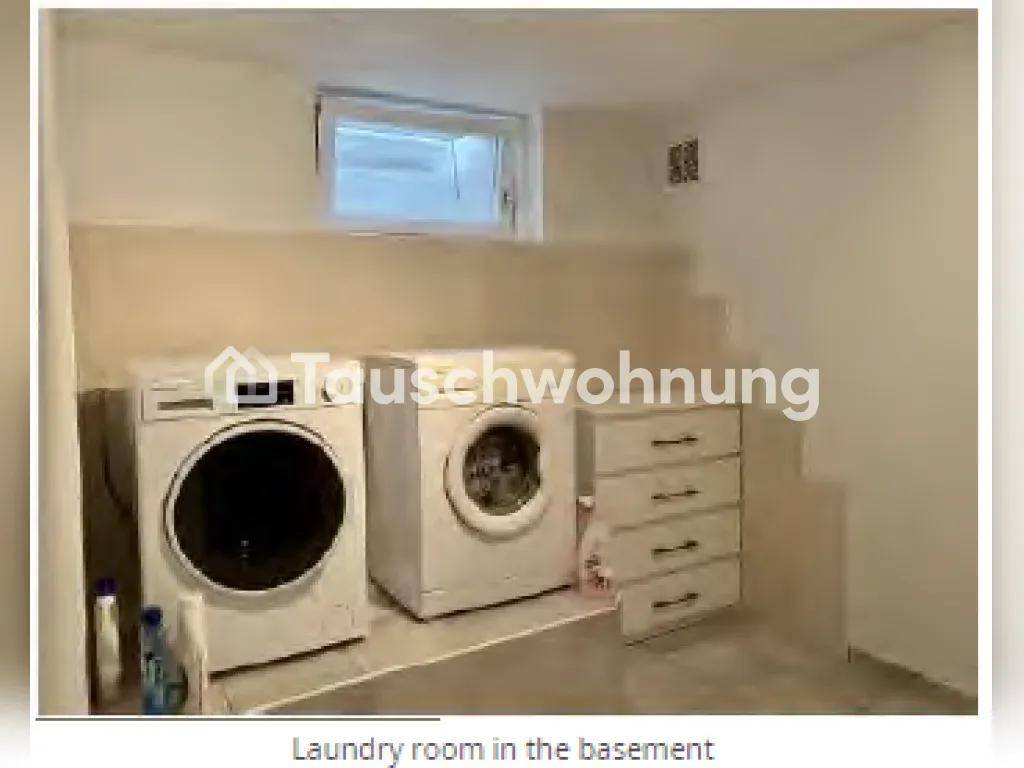 Waschküche im Keller mit Waschmaschinen und einem kleinen Fenster.