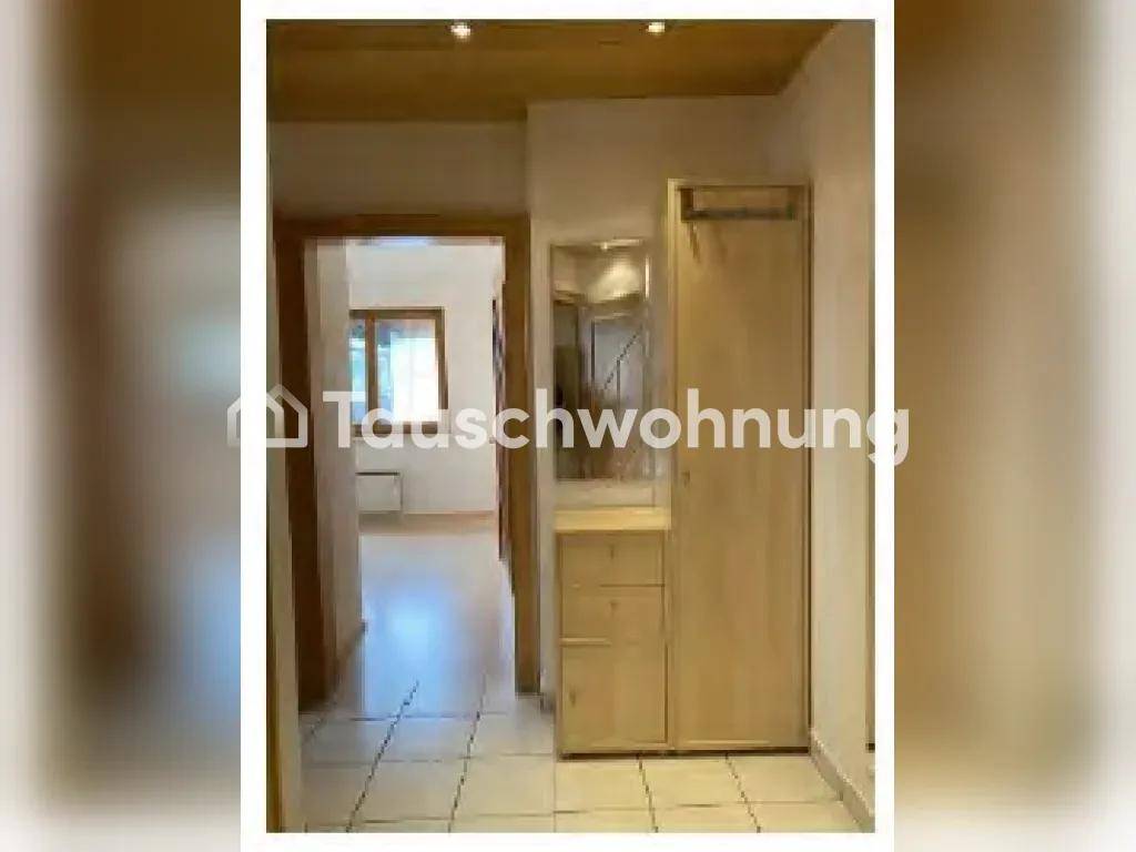 Eingangsbereich mit Fliesenboden, Garderobe und einem Spiegel.