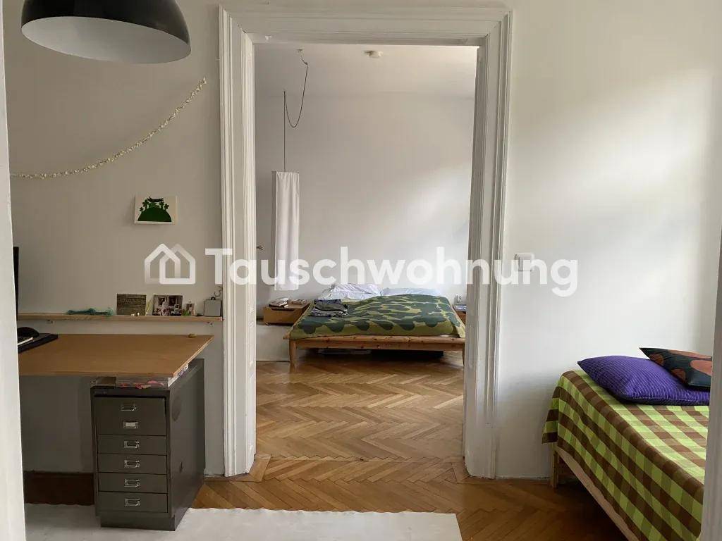 Blick durch eine Tür in ein Schlafzimmer mit Holzbett und Fischgrätparkett.