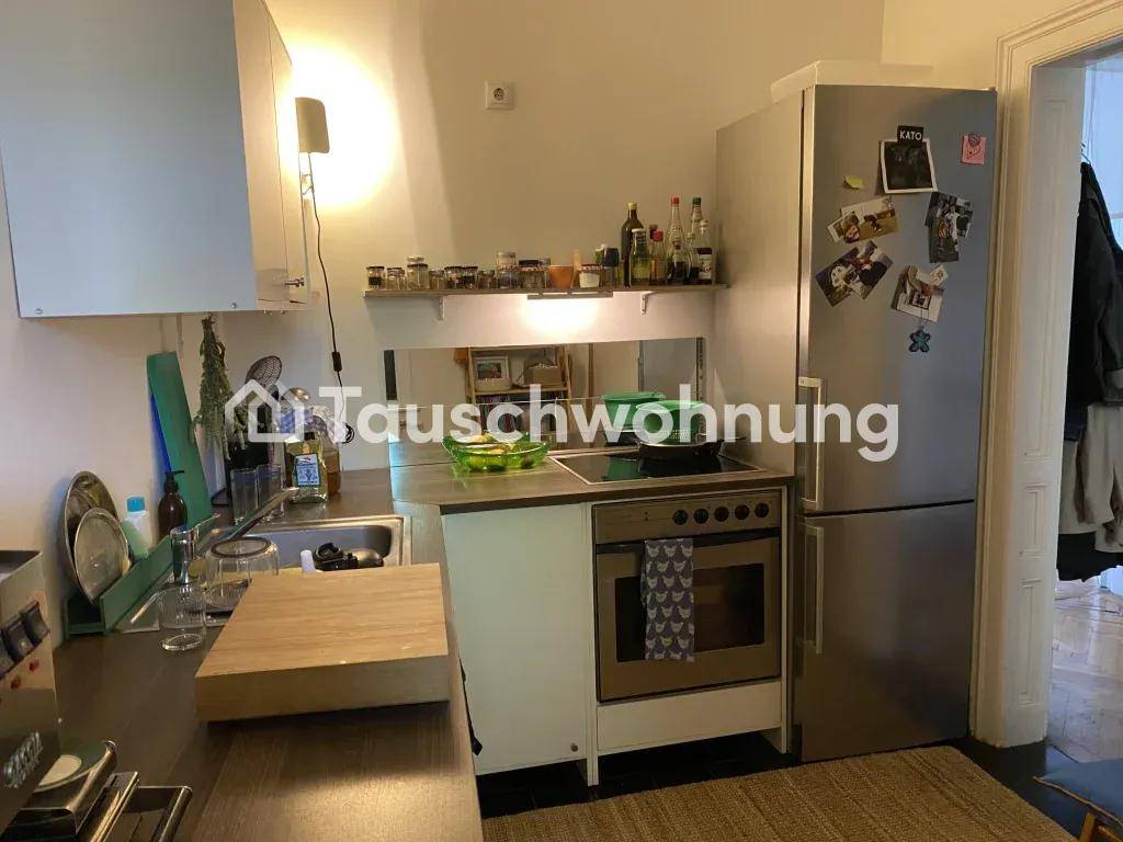 Kompakte Küche mit Herd, Backofen und Kühlschrank, ideal für kleine Haushalte.