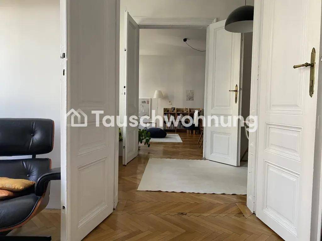 Blick vom Schlafzimmer durch offene Flügeltüren in den hellen Wohnbereich.