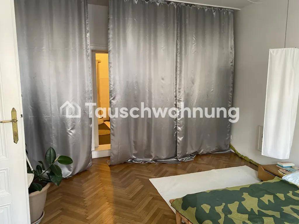 Schlafzimmer mit Vorhängen vor einem Durchgang, der zu einem weiteren Raum führt.