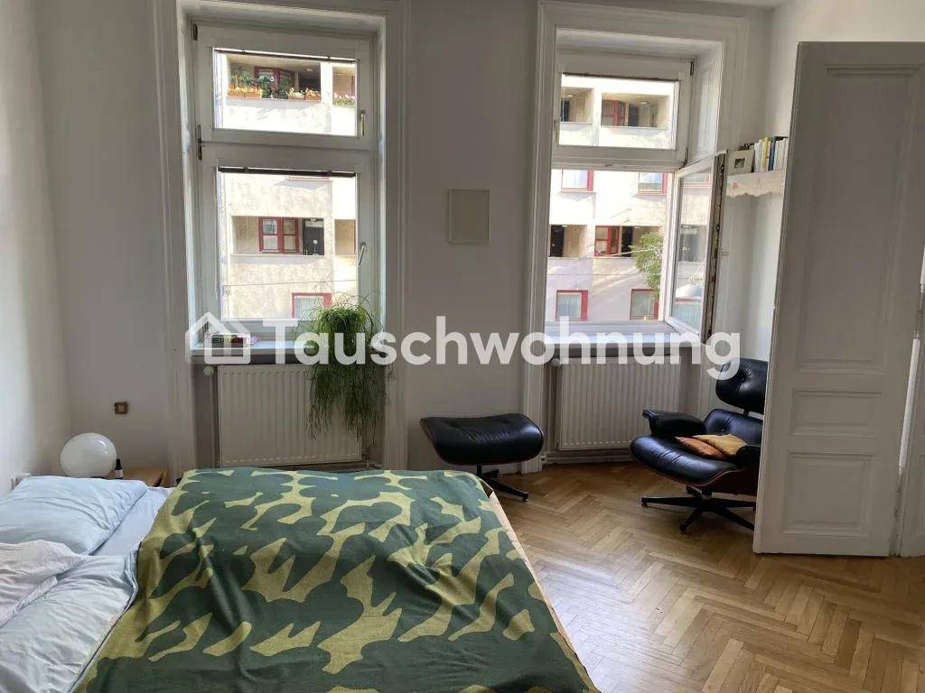 Helles Schlafzimmer mit Doppelbett, zwei großen Fenstern und einem bequemen Sessel.