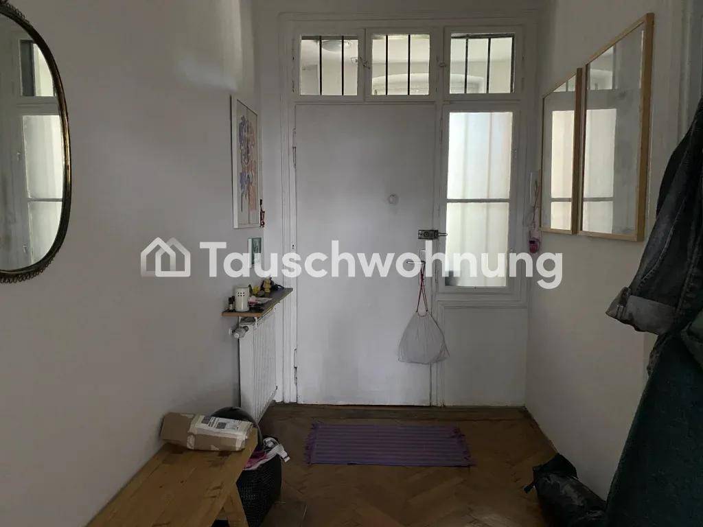 Eingangsbereich mit Haustür, Oberlichtfenstern und einem Spiegel an der Wand.