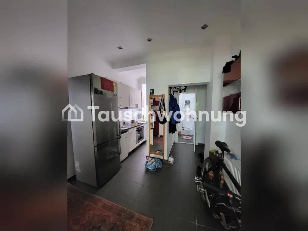 Eingangsbereich mit Kühlschrank, der in die Küche und zu einem weiteren Raum führt.