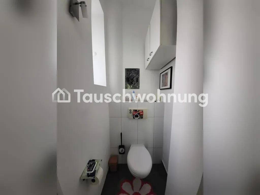 Kleines Gäste-WC mit wandhängender Toilette und Fliesen an den Wänden.