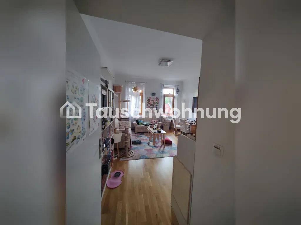 Flur mit Holzboden, der in das helle Wohnzimmer führt, offener Übergang.