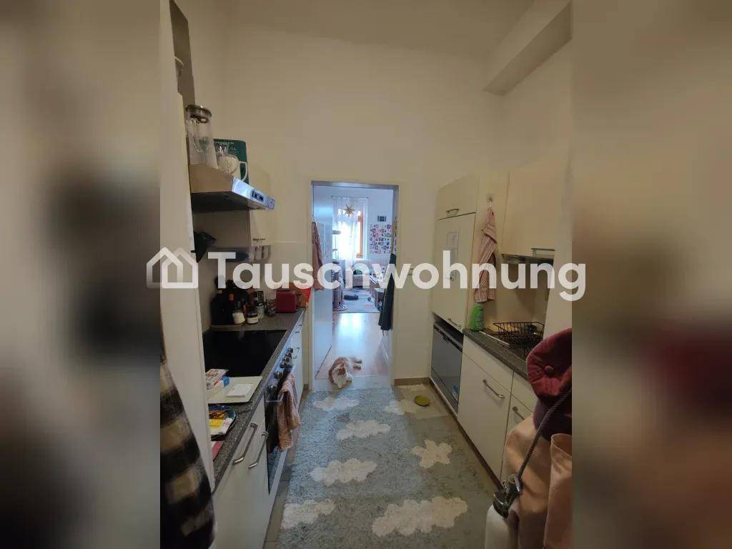 Schmale Küche mit Durchgang zu einem weiteren Raum, funktional eingerichtet.