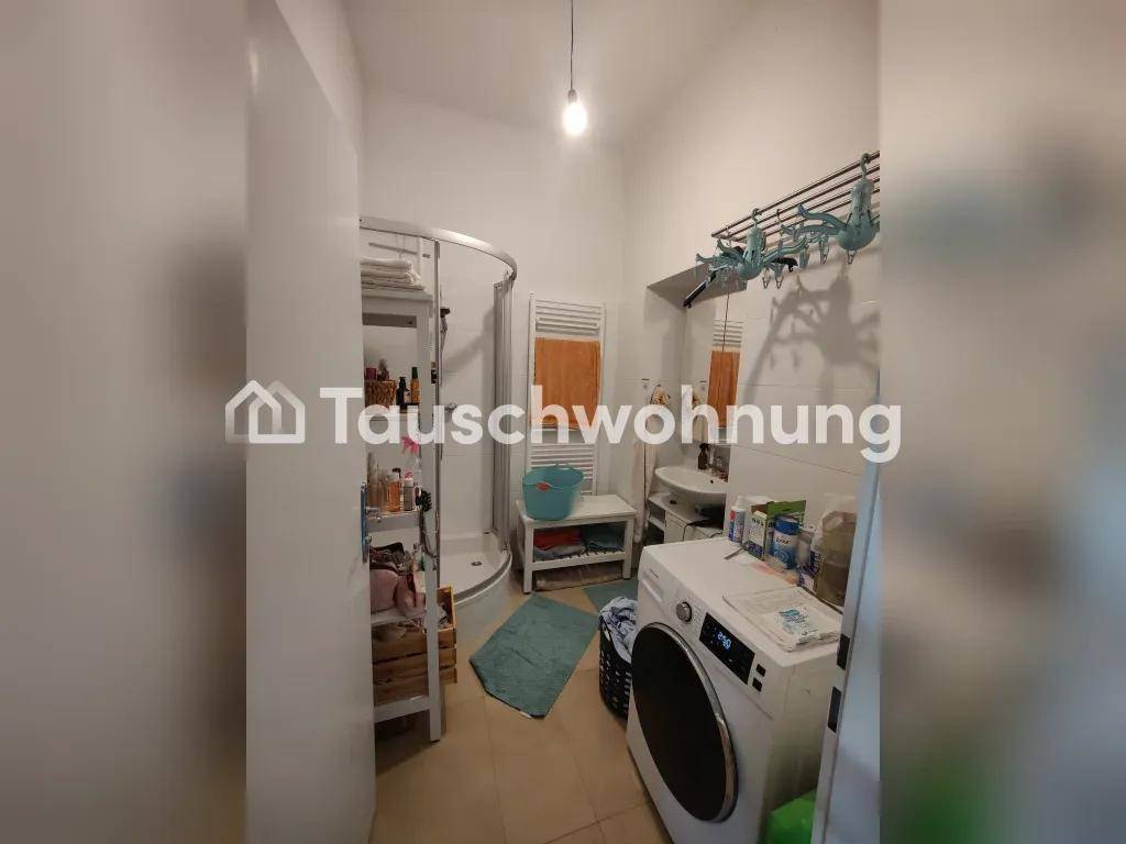 Badezimmer mit Duschkabine, Waschbecken und Waschmaschine, praktischer Heizkörper.