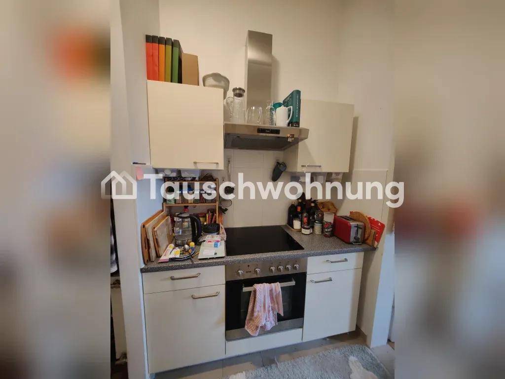 Kompakte Küche mit Herd, Backofen und Dunstabzugshaube, praktischer Arbeitsbereich.