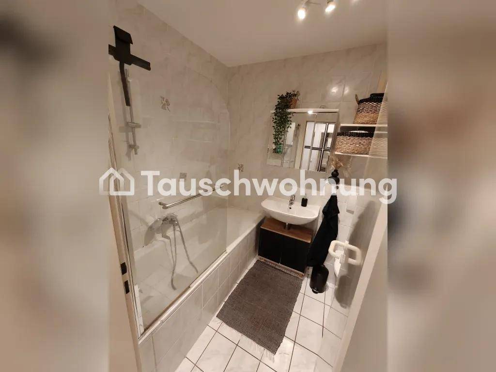 Modernes Badezimmer mit Badewanne, Duschabtrennung und hellen Fliesen.