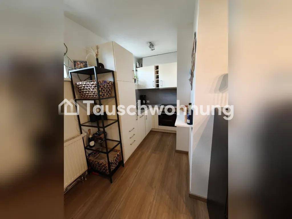 Kleine, funktionale Küche mit weißen Schränken und Holzboden.