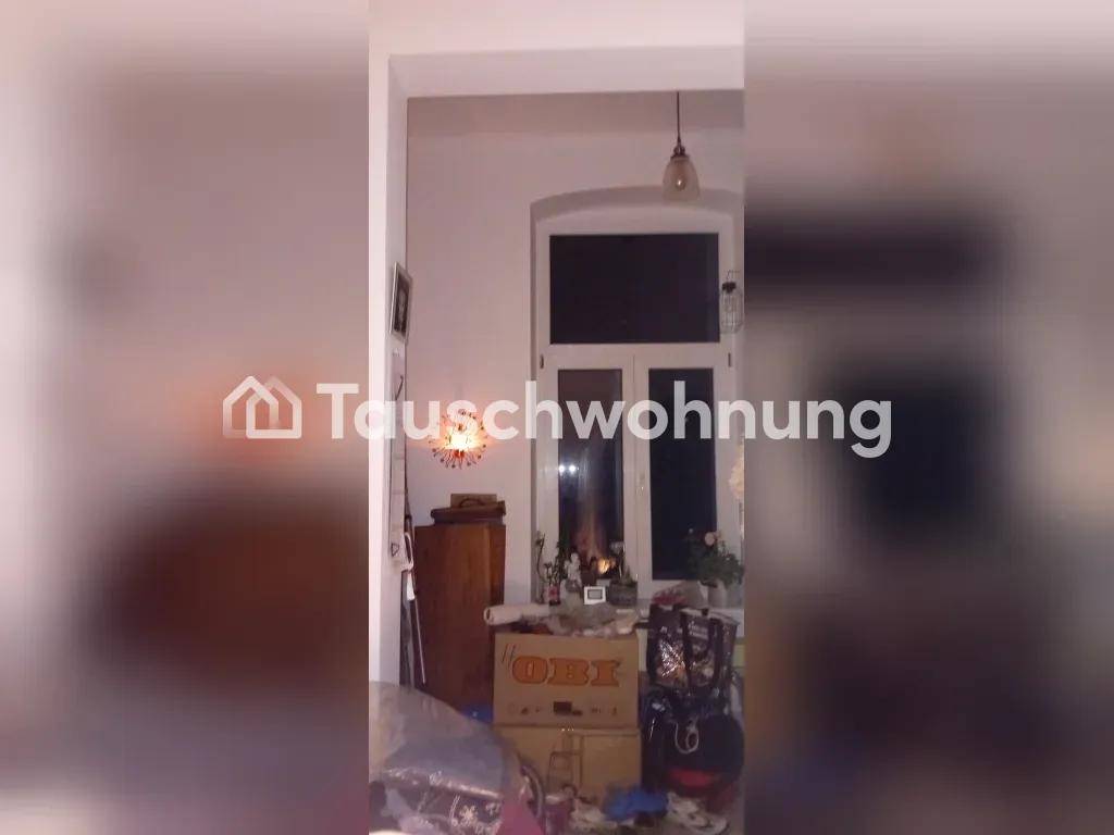 Unaufgeräumter Raum mit einem Fenster, verschiedenen Kartons und einer dekorativen Lampe.