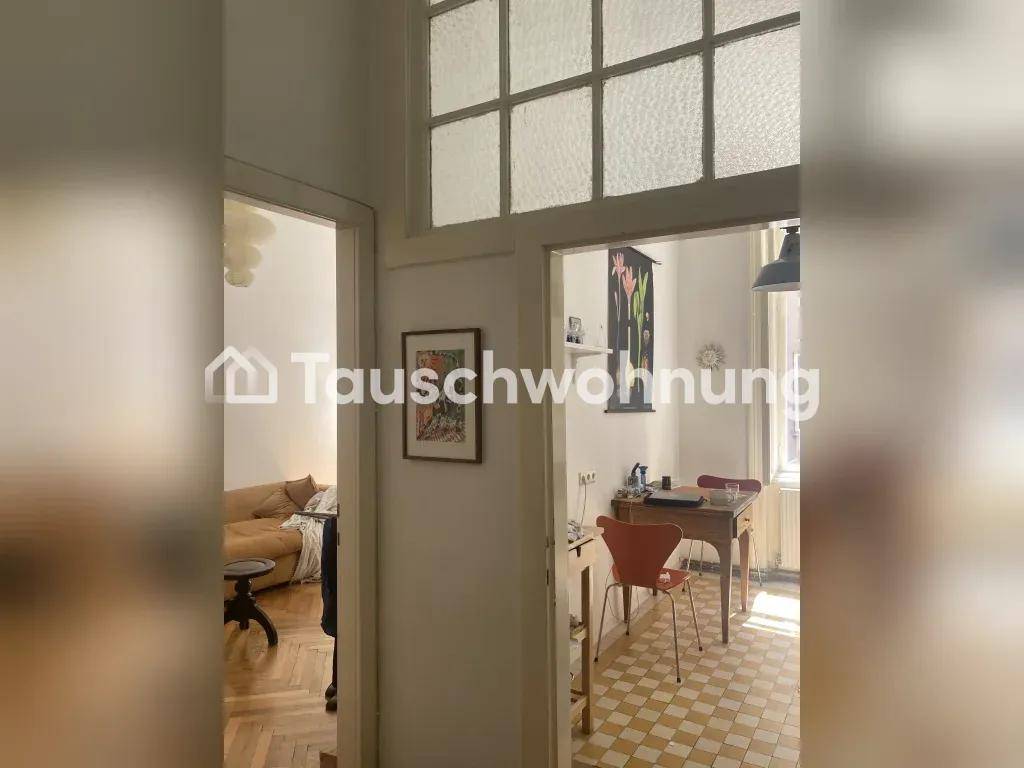 Flur mit Oberlichtfenstern, der zu einem Wohnzimmer und einer Küche führt.