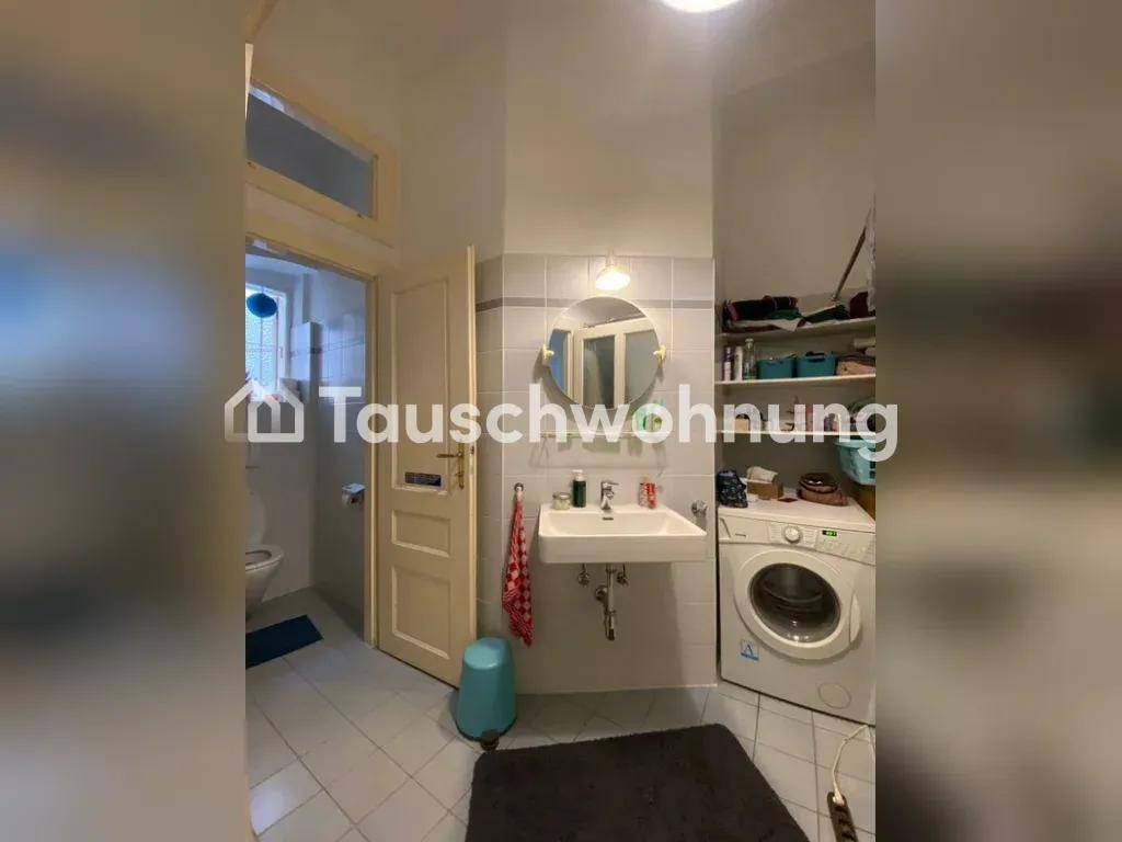 Badezimmer mit Waschbecken, Waschmaschine und einer Tür zum WC.