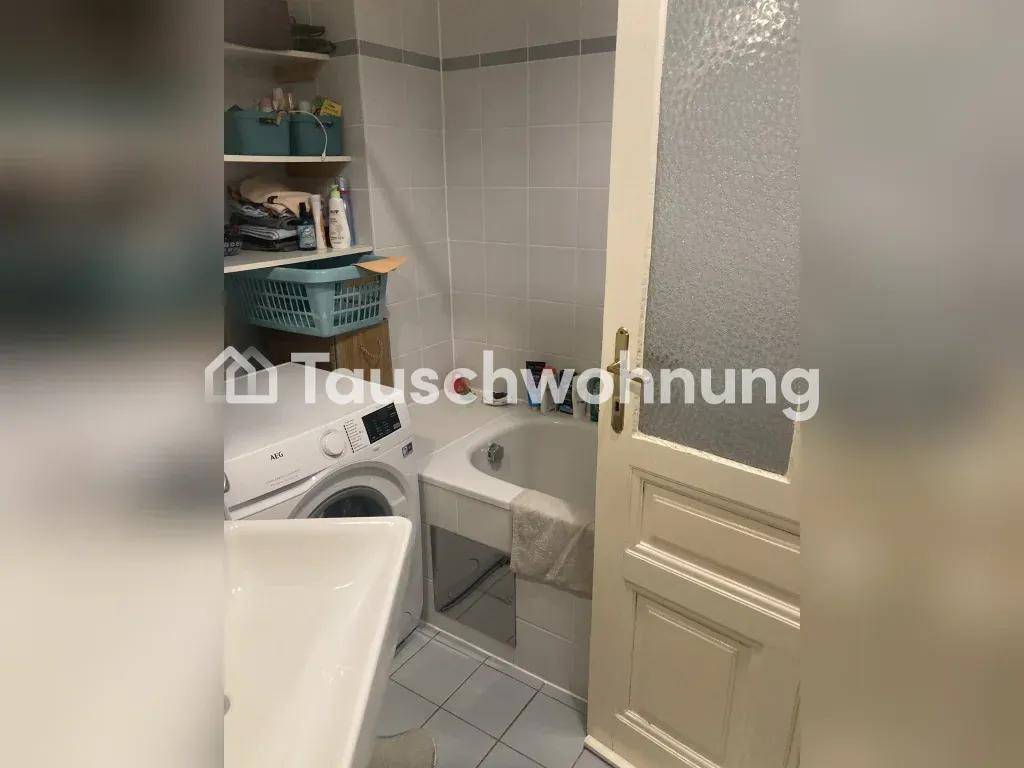 Badezimmer mit Badewanne, Waschmaschine und Regal für Utensilien.