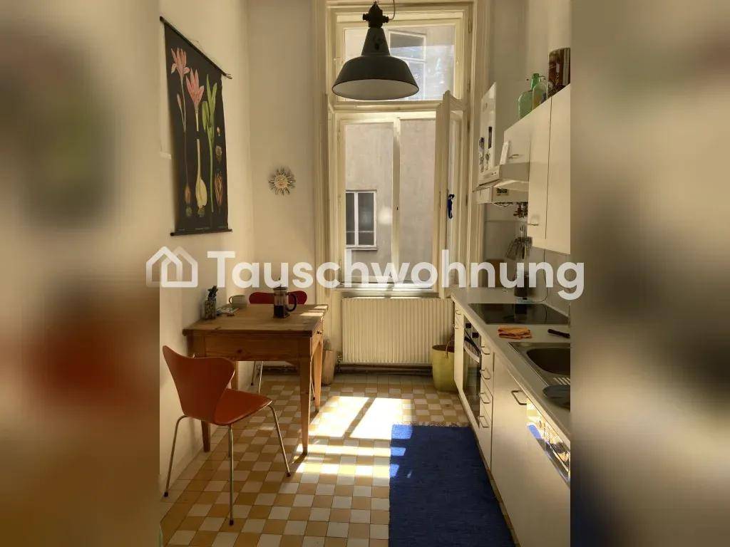 Schmale Küche mit karierten Fliesen, einem Esstisch und einem Fenster.