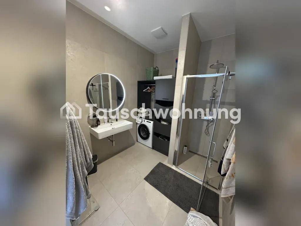 Modernes Badezimmer mit ebenerdiger Dusche, Waschbecken und Waschmaschine.