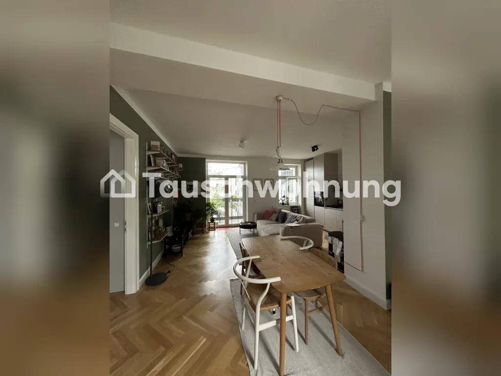 Offener Wohn- und Essbereich mit Holztisch, Parkettboden und moderner Einrichtung.