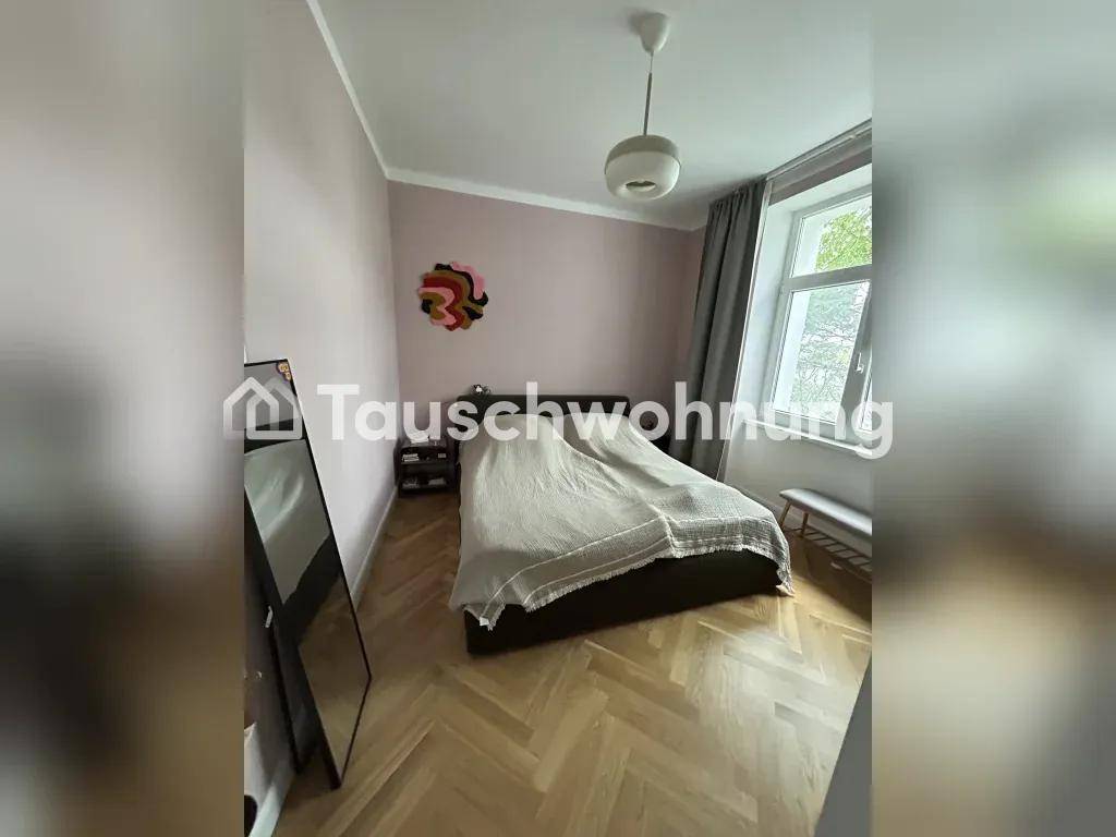 Schlafzimmer mit Doppelbett, großem Fenster und hellem Parkettboden.