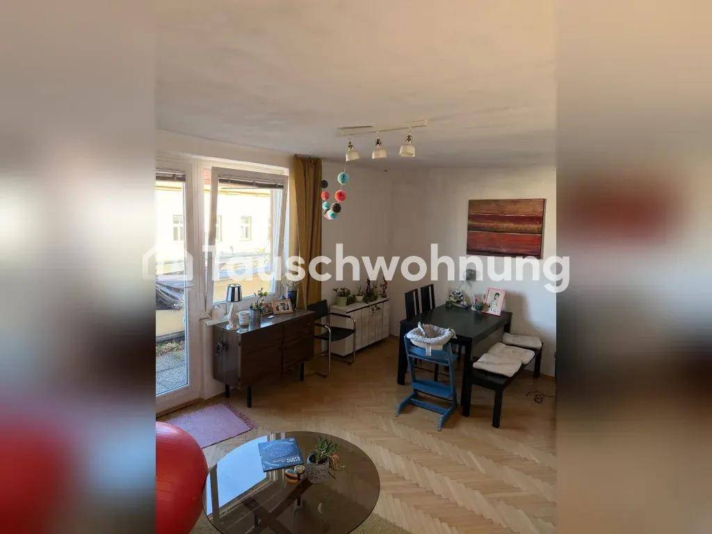 Geräumiger Wohn- und Essbereich mit Zugang zu einem Außenbereich und hellem Parkettboden.