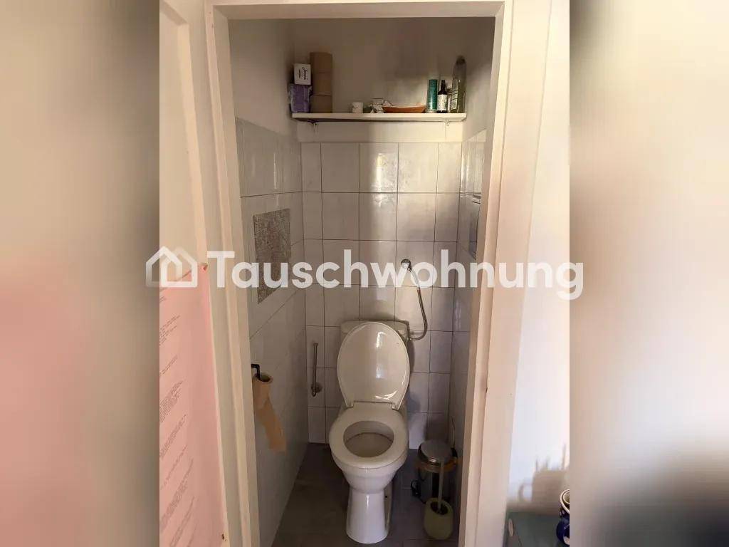 Kleines separates WC mit weißen Fliesen und einfacher Ausstattung.