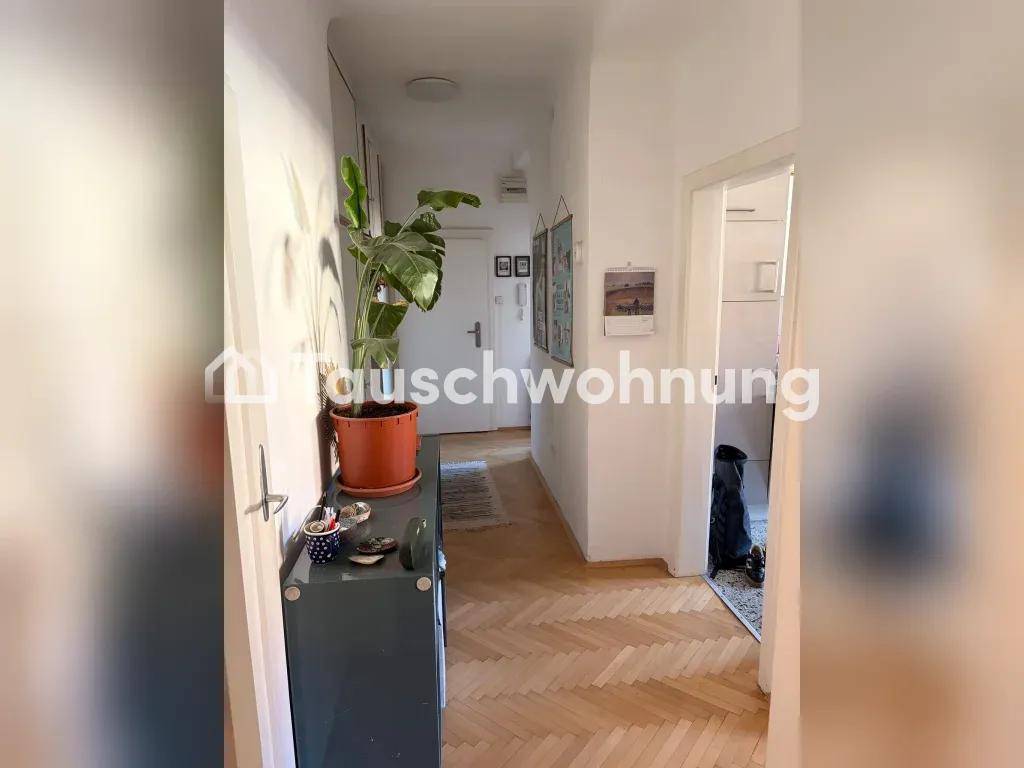 Heller Flur mit Fischgrätparkettboden und einer dekorativen Pflanze.