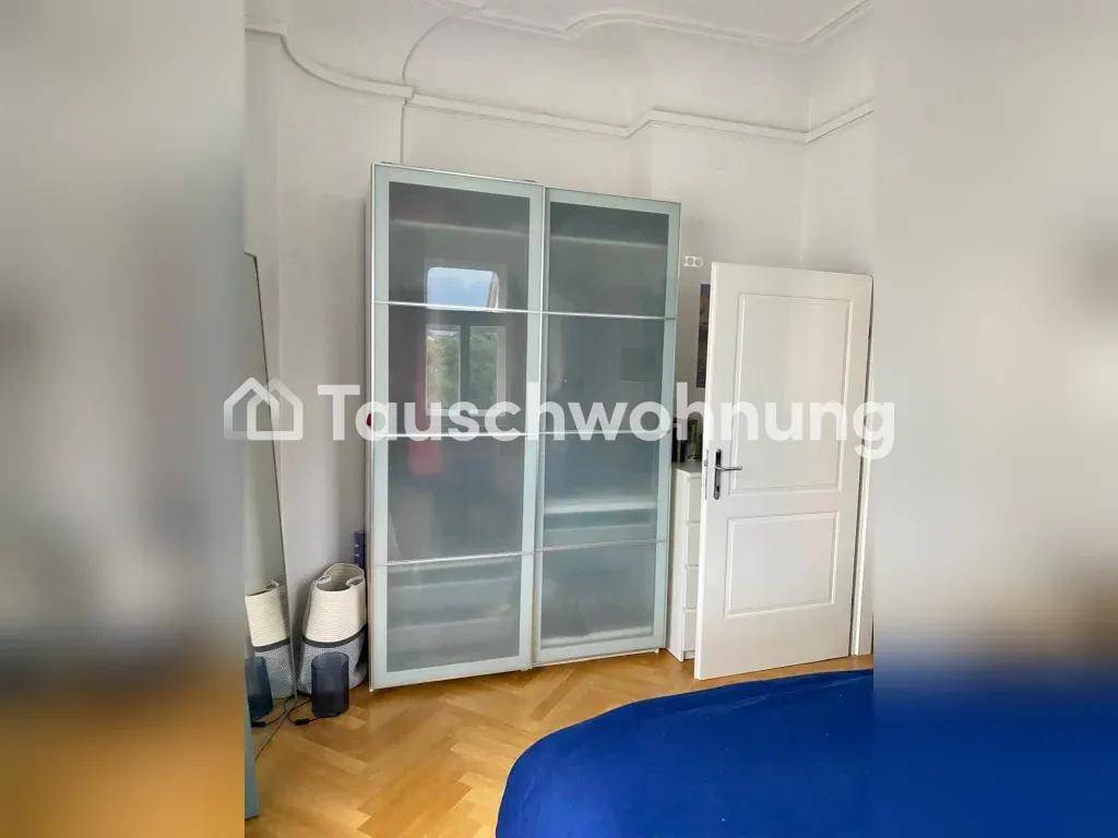 Schlafzimmer mit großem Kleiderschrank mit Schiebetüren und Parkettboden.