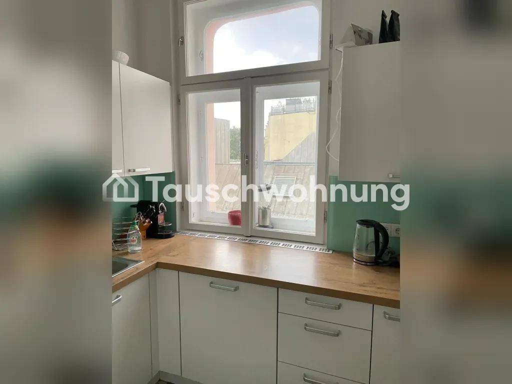 Funktionale Küche mit weißen Schränken, Holz-Arbeitsplatte und Blick nach draußen.