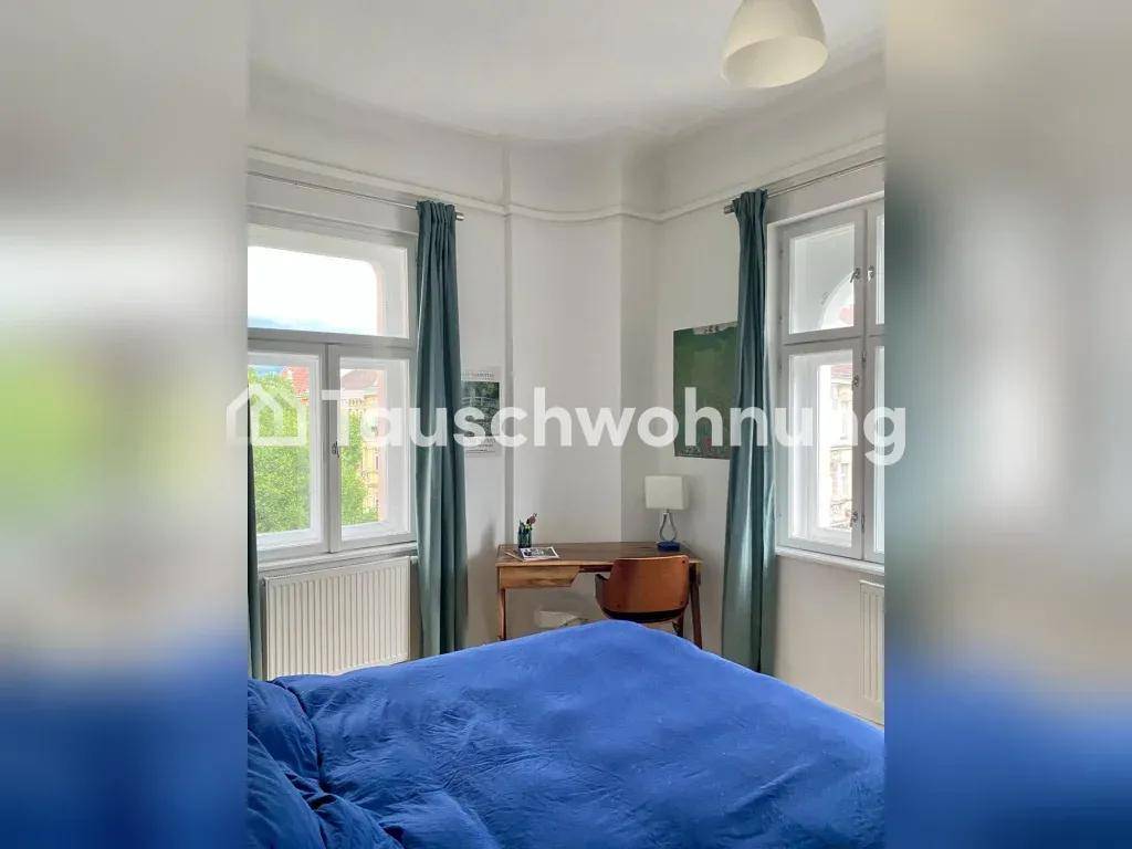 Gemütliches Schlafzimmer mit Parkettboden, Schreibtisch und Blick aus dem Fenster.